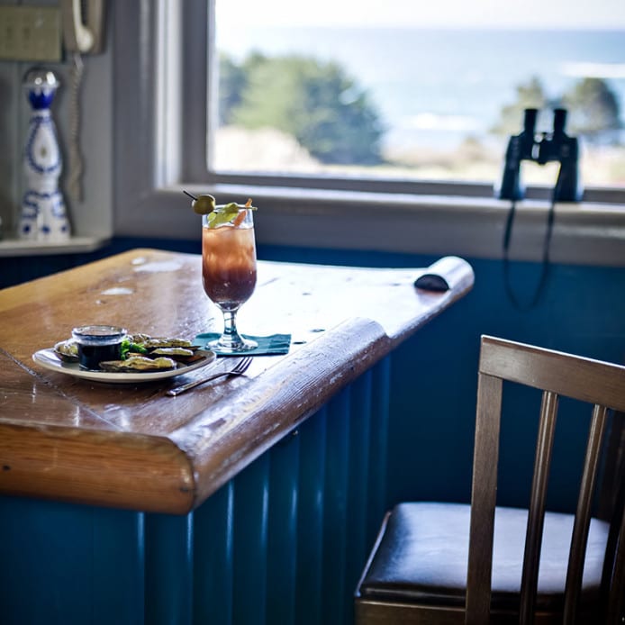Bloody Mary and shellfish on a wooden bar with ocean view